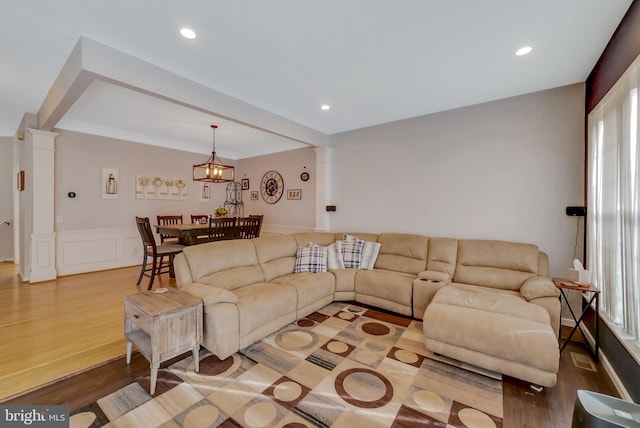 living room featuring ornate columns and hardwood / wood-style floors