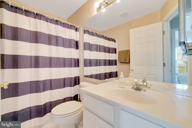 bathroom with vanity, toilet, and walk in shower