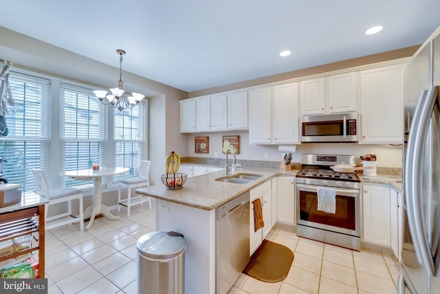 kitchen with white cabinetry, sink, hanging light fixtures, kitchen peninsula, and stainless steel appliances