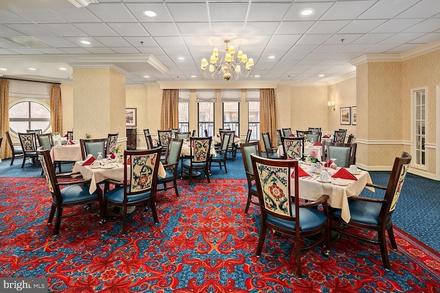 dining space with an inviting chandelier, ornamental molding, and carpet