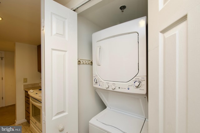 laundry room featuring tile patterned flooring and stacked washer / dryer