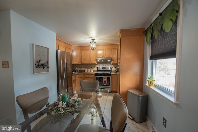 kitchen with tasteful backsplash, appliances with stainless steel finishes, and light brown cabinetry