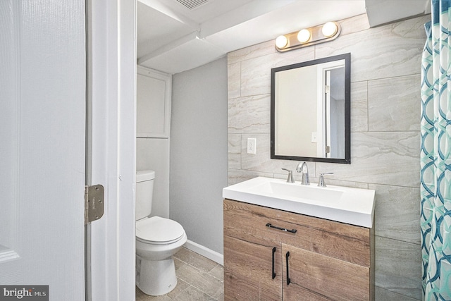 bathroom featuring walk in shower, toilet, tile walls, vanity, and backsplash