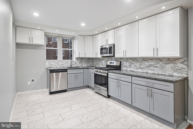 kitchen with sink, gray cabinetry, white cabinetry, stainless steel appliances, and decorative backsplash