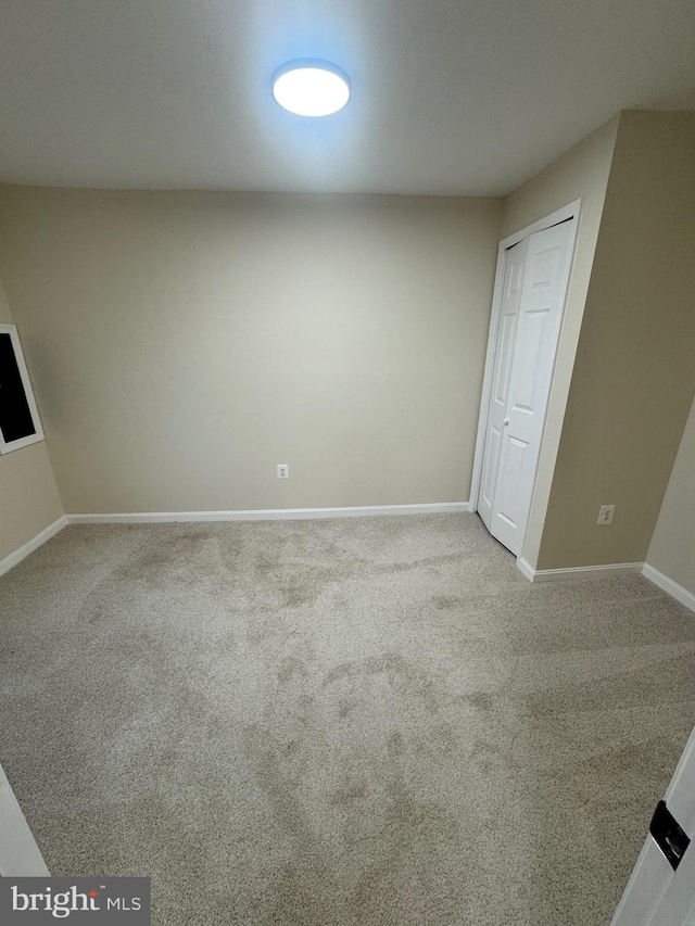 interior space featuring light colored carpet and a closet