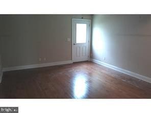 unfurnished room with dark hardwood / wood-style floors