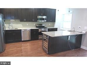 kitchen featuring sink, stainless steel appliances, and dark hardwood / wood-style floors