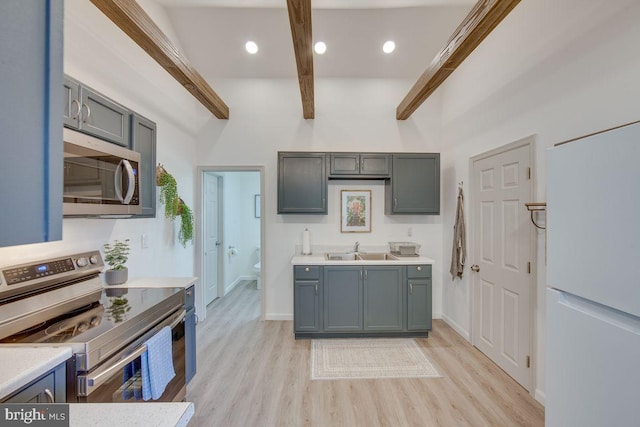 kitchen with sink, light hardwood / wood-style flooring, appliances with stainless steel finishes, a high ceiling, and beamed ceiling