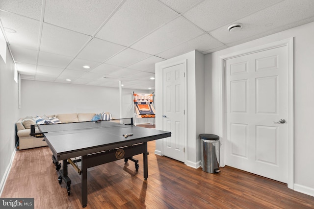 recreation room with dark wood-type flooring and a paneled ceiling