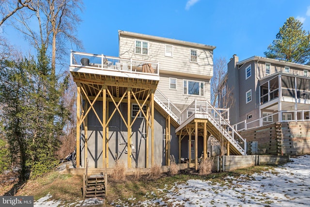 snow covered rear of property featuring a deck