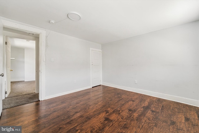 empty room featuring baseboards and wood finished floors