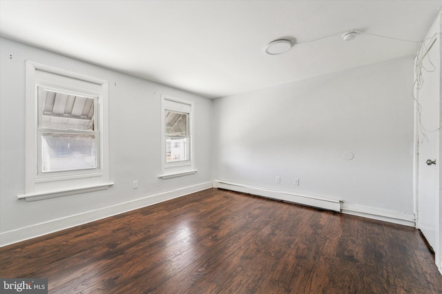 spare room featuring baseboards, baseboard heating, and wood finished floors