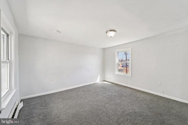 spare room with a baseboard radiator, baseboards, and carpet floors