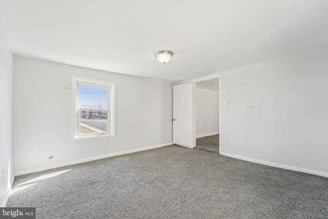 unfurnished room with baseboards and carpet floors