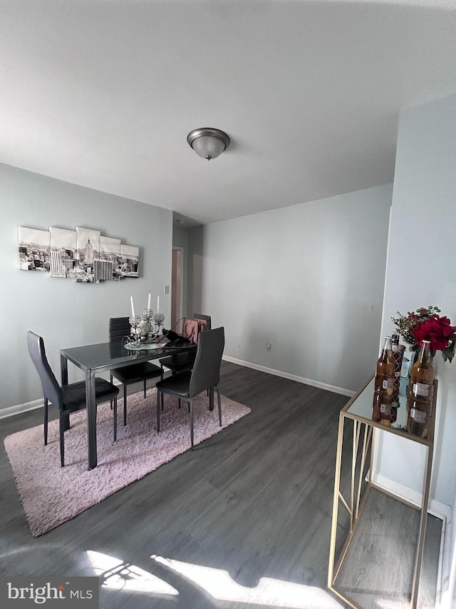 dining space with dark wood finished floors and baseboards