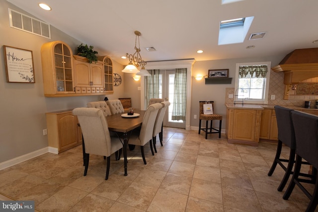 dining space featuring sink, plenty of natural light, and a skylight