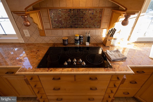 kitchen with black electric cooktop and tasteful backsplash