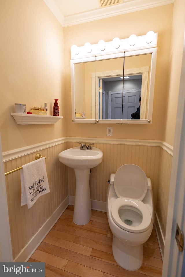 bathroom with crown molding and hardwood / wood-style flooring