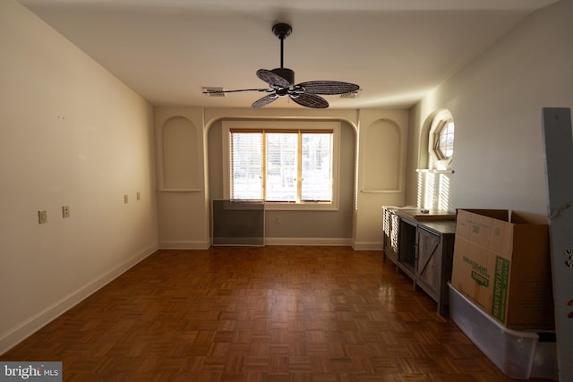 interior space with ceiling fan and dark parquet floors