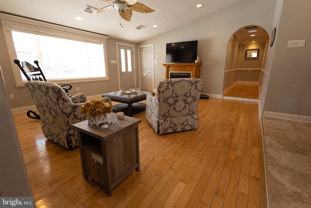 living room featuring vaulted ceiling, ceiling fan, and light wood-type flooring