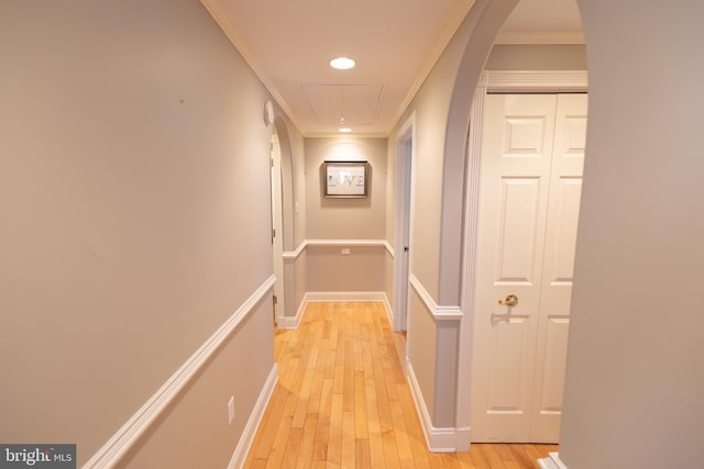 hallway with crown molding and light hardwood / wood-style flooring