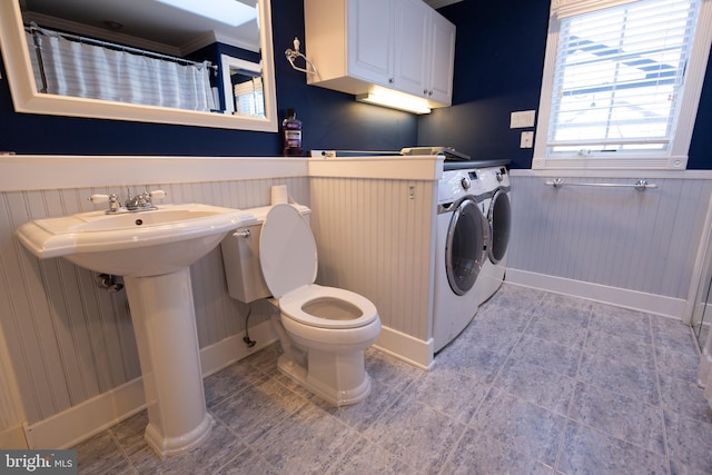 bathroom with sink, toilet, and washing machine and clothes dryer