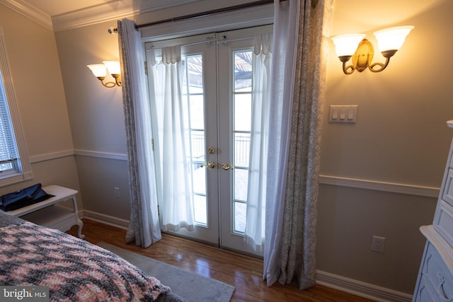 bedroom with wood-type flooring, ornamental molding, access to exterior, and french doors