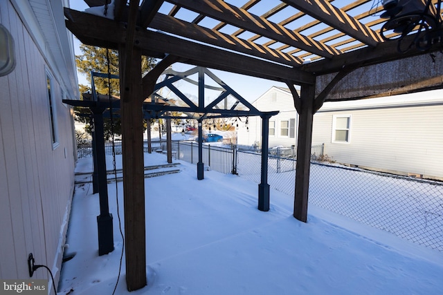 snow covered patio with a pergola