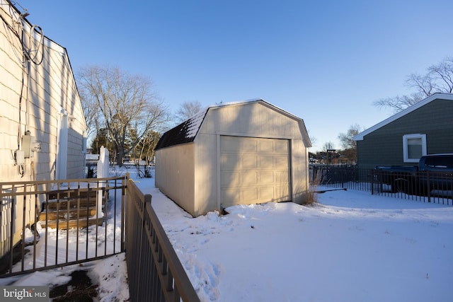 snow covered structure featuring a garage