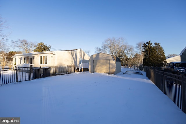 yard layered in snow featuring a storage unit