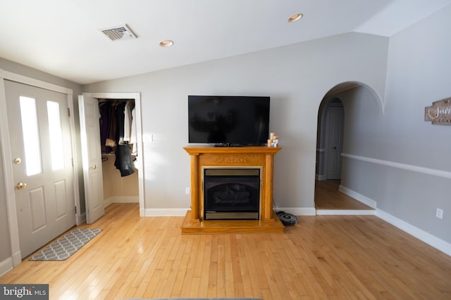 unfurnished living room featuring lofted ceiling and light hardwood / wood-style flooring