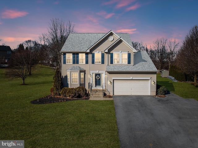 view of front of property featuring a garage and a lawn