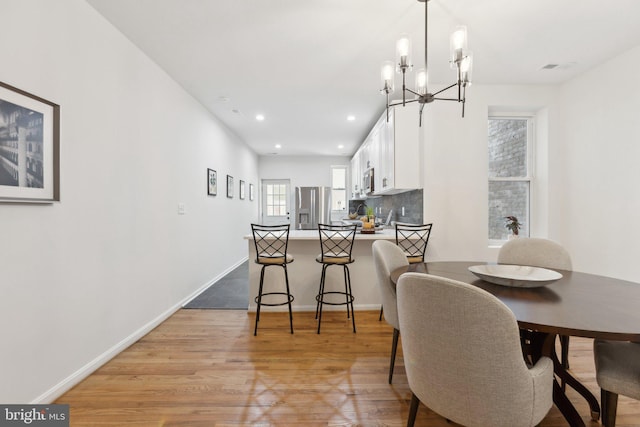 dining room with an inviting chandelier and light wood-type flooring