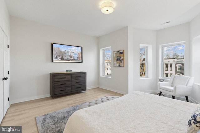 bedroom featuring light hardwood / wood-style floors and multiple windows