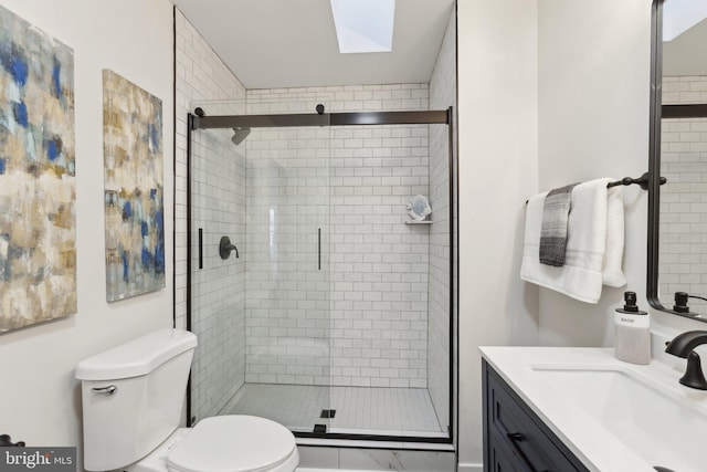 bathroom featuring vanity, walk in shower, and toilet