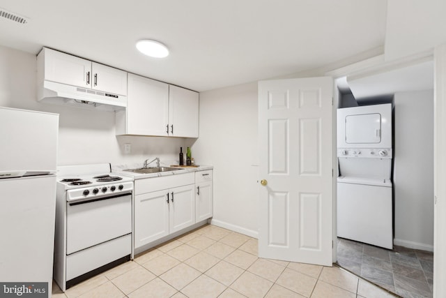 kitchen with white cabinetry, stacked washing maching and dryer, sink, and white appliances