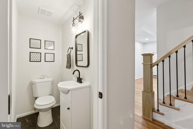 bathroom with vanity, toilet, and wood-type flooring