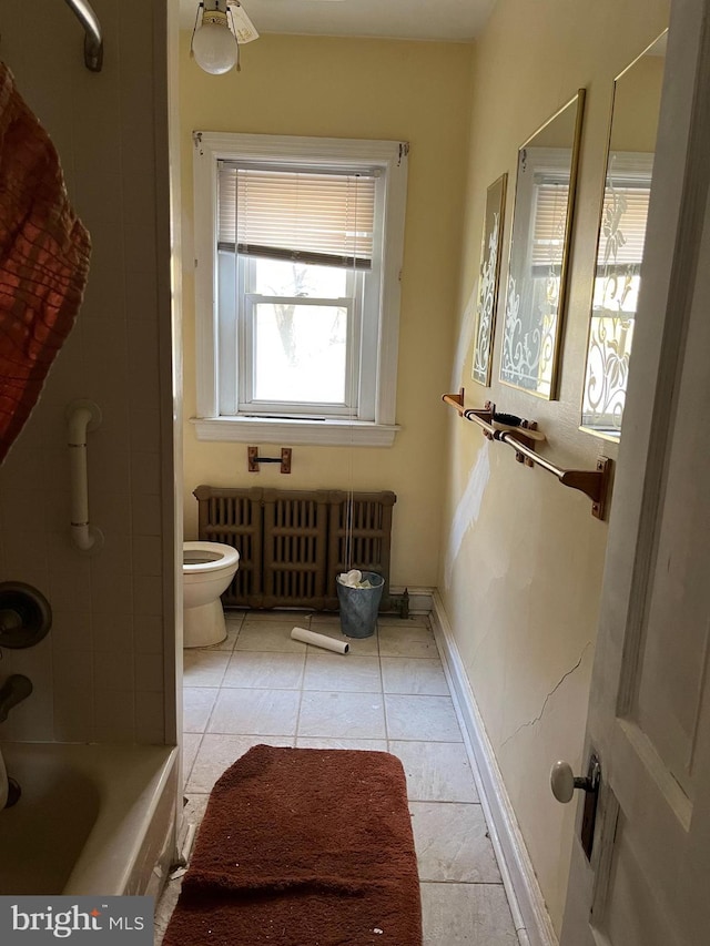 bathroom with radiator heating unit, toilet, tile patterned flooring, and a bathtub