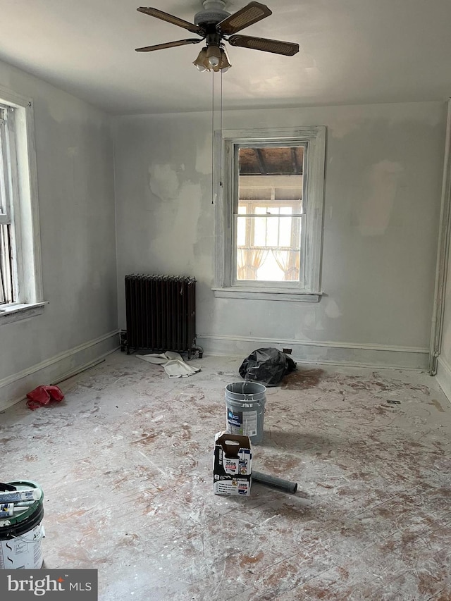 unfurnished room featuring radiator heating unit and ceiling fan