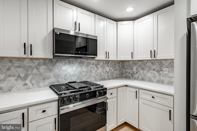 kitchen with tasteful backsplash, stainless steel appliances, and white cabinets