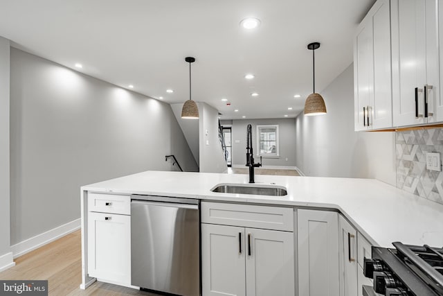 kitchen featuring appliances with stainless steel finishes, sink, pendant lighting, and white cabinets