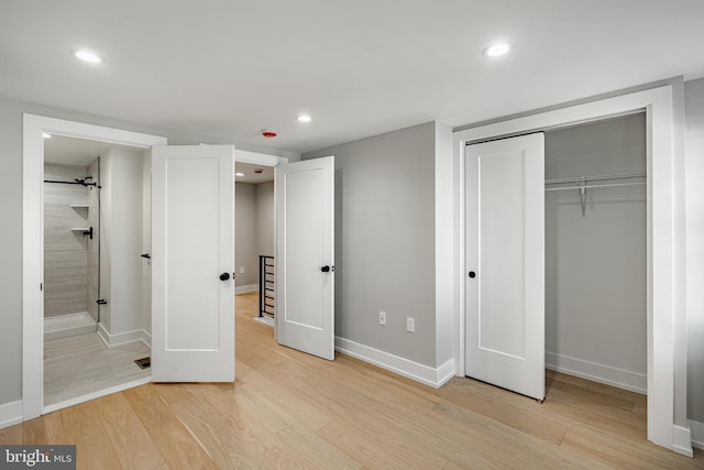 unfurnished bedroom with connected bathroom, a closet, and light wood-type flooring