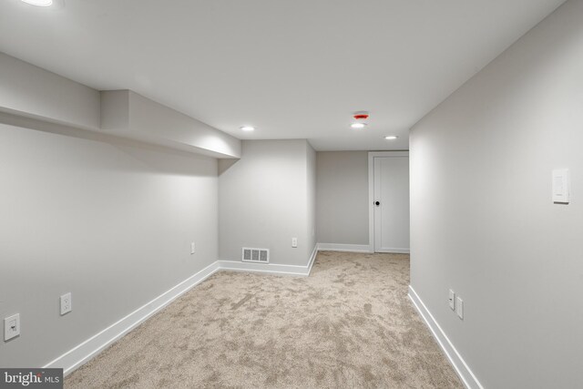 basement featuring light colored carpet