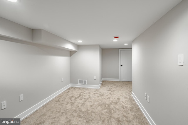 basement featuring light colored carpet