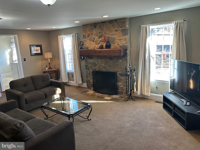 living area featuring a stone fireplace, recessed lighting, and baseboards