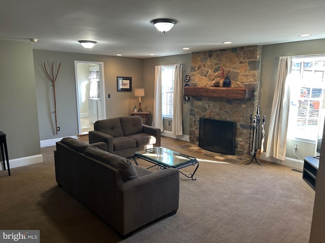 carpeted living room with a stone fireplace, recessed lighting, and baseboards