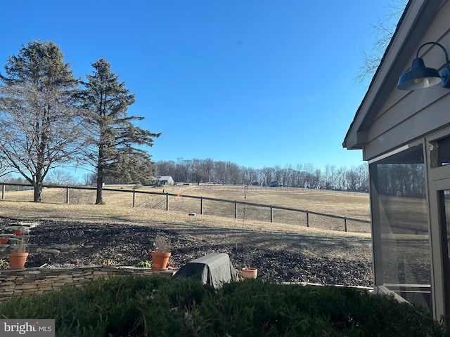 view of yard featuring a rural view and fence