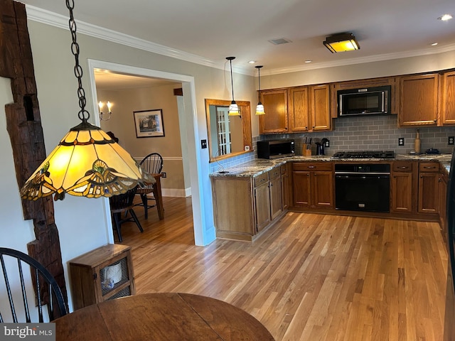 kitchen with brown cabinetry, black appliances, light wood-style floors, and tasteful backsplash