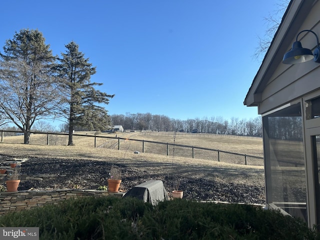 view of yard with a rural view and fence