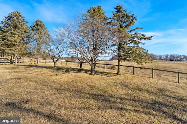 view of yard with a rural view and fence